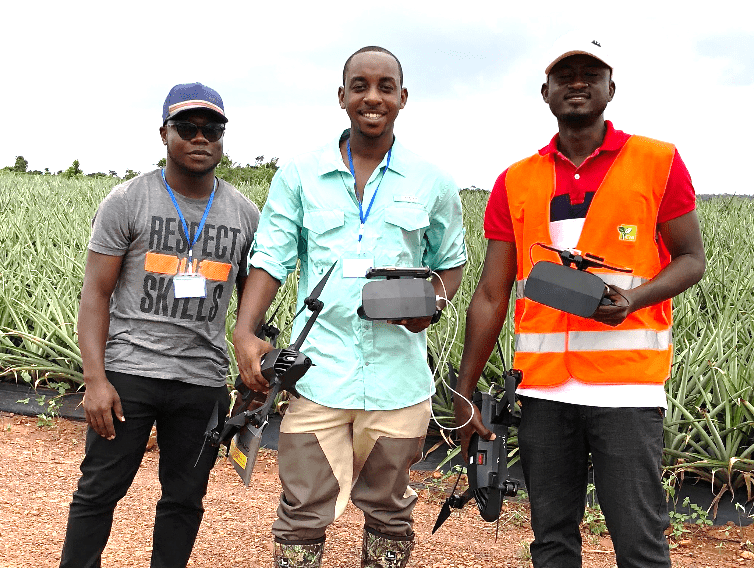 Three guys holding drones